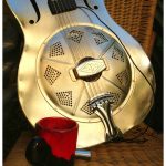 Steel bodied resonator guitar and Tim Lee's favourite coffee cup.